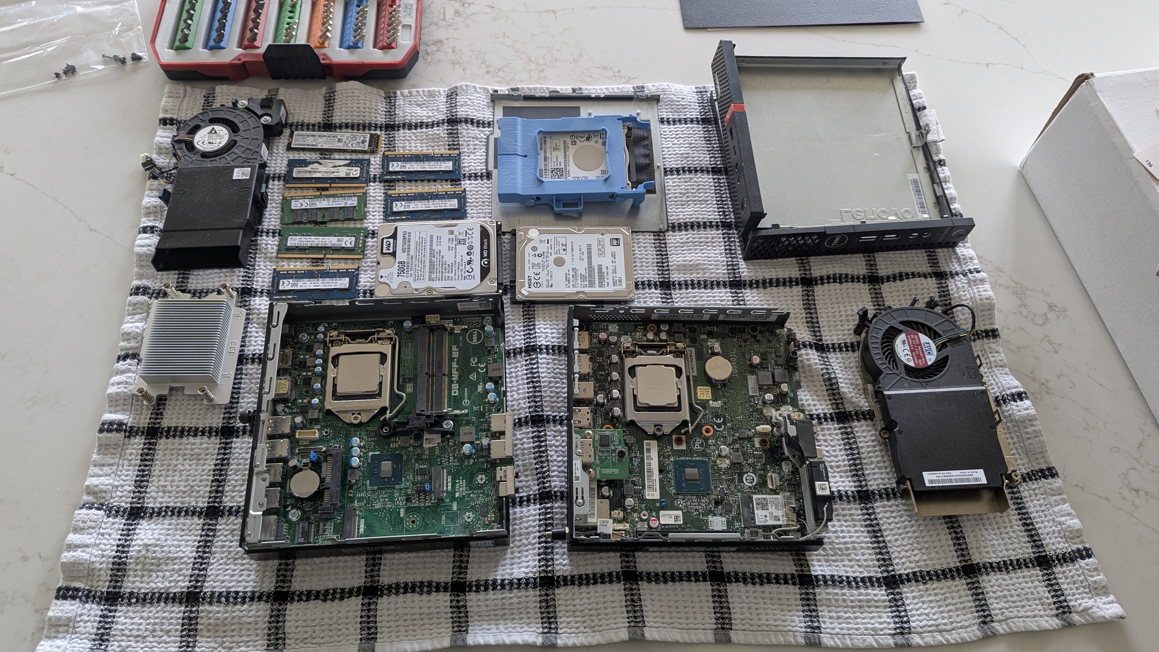 Salvaged RAM sticks, hard drives, fans, and two bare motherboards laid out on a towel